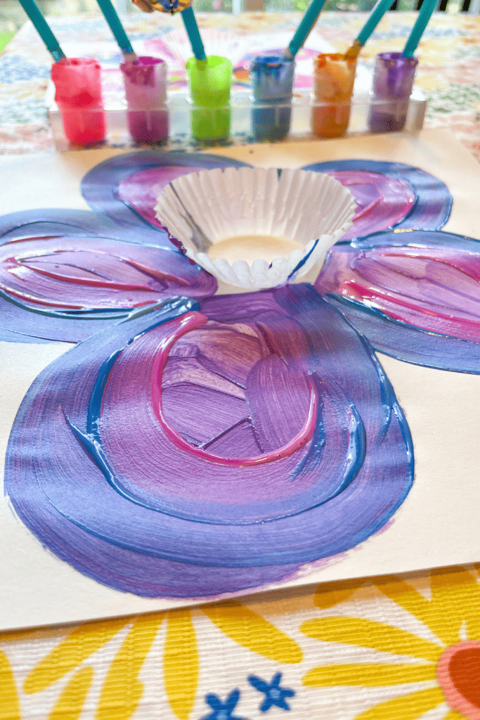 An up-close view of blue, purple, and pink petals painted on a piece of Cupcake Liner Flower Art.