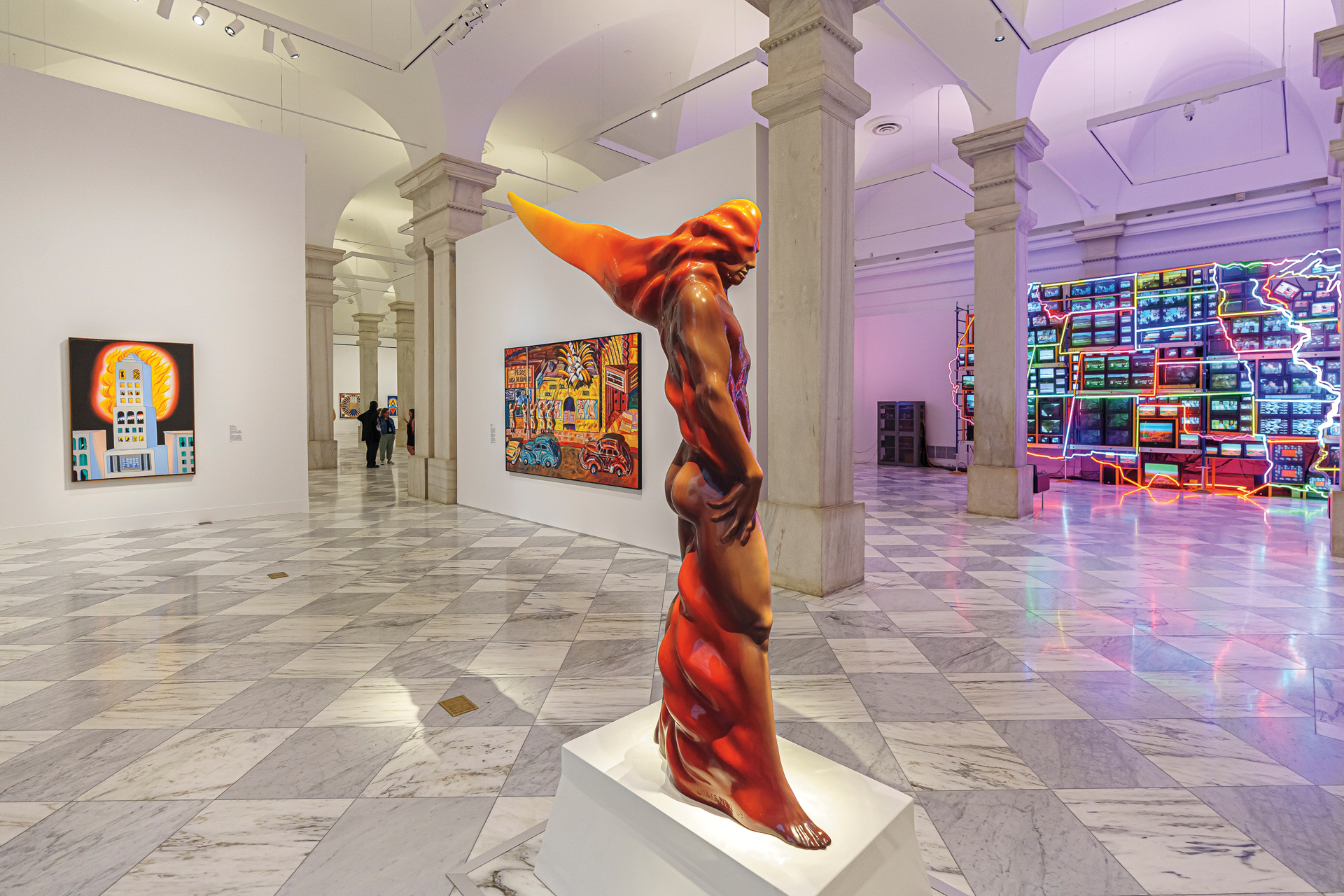 A gallery room with marble floors, a fierce figural sculpture, a neon light work, and paintings on the walls.